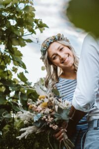 Naturfotos von einem lachenden Frauenpaar mit Blumenkranz, verliebtes Paar im Freien, Hochzeitsbild, romantisch, natürliche Schönheit, Lifestyle- und Hochzeitsfotografie, Freude, Liebe, Natur, outdoor, emotionale Portraits.